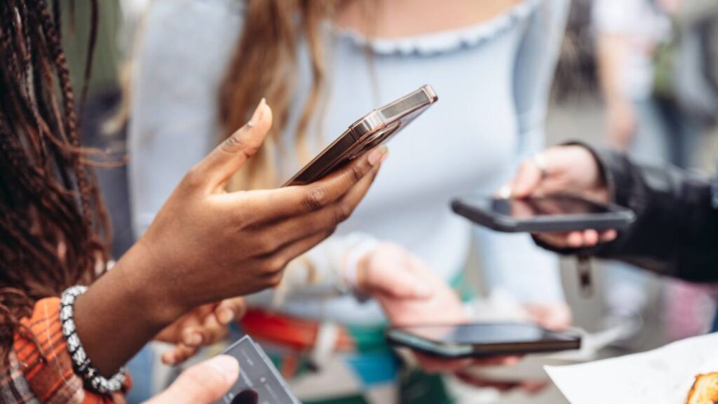 3 paar handen die smartphones vasthouden