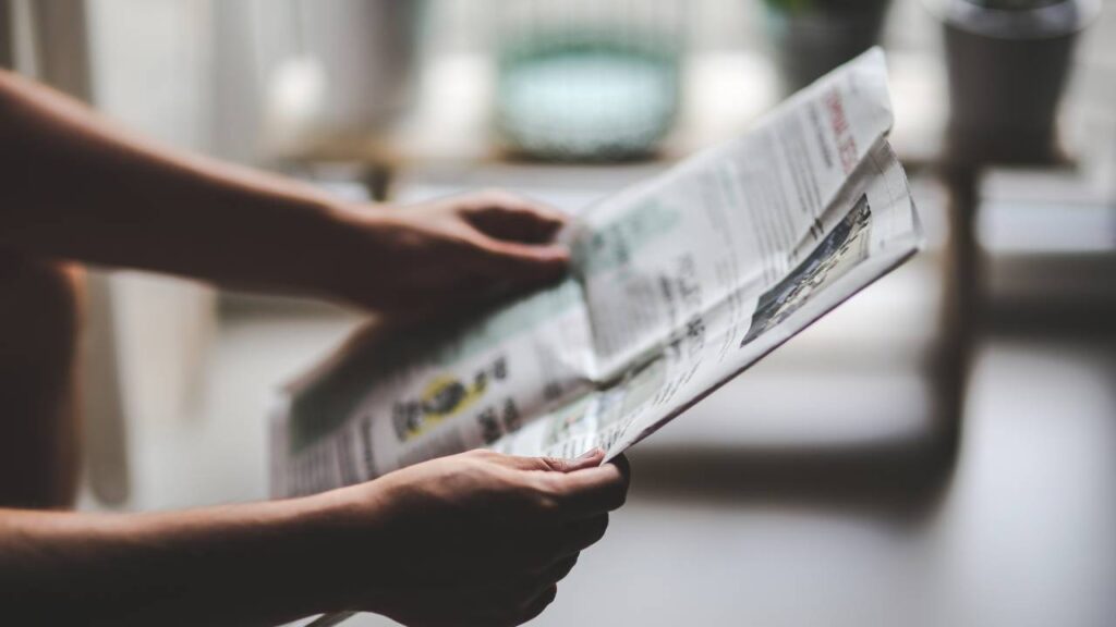 iemand die een krant openslaat